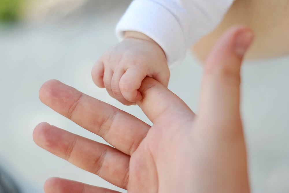 写真:親の人差し指を握る乳幼児の手