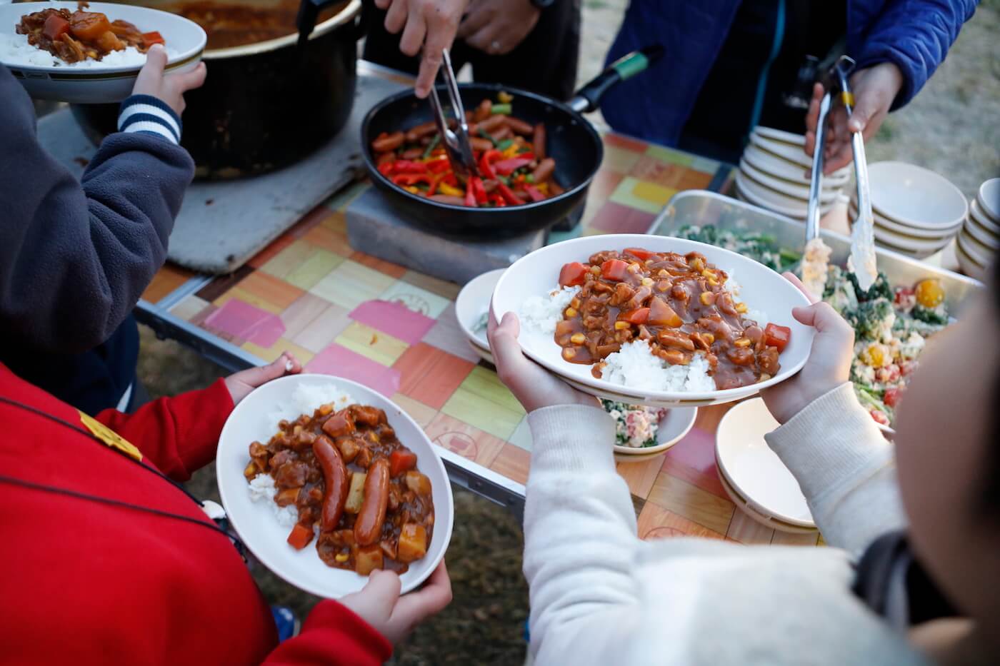 写真:カレーライスを盛った皿を手に持つ子ども