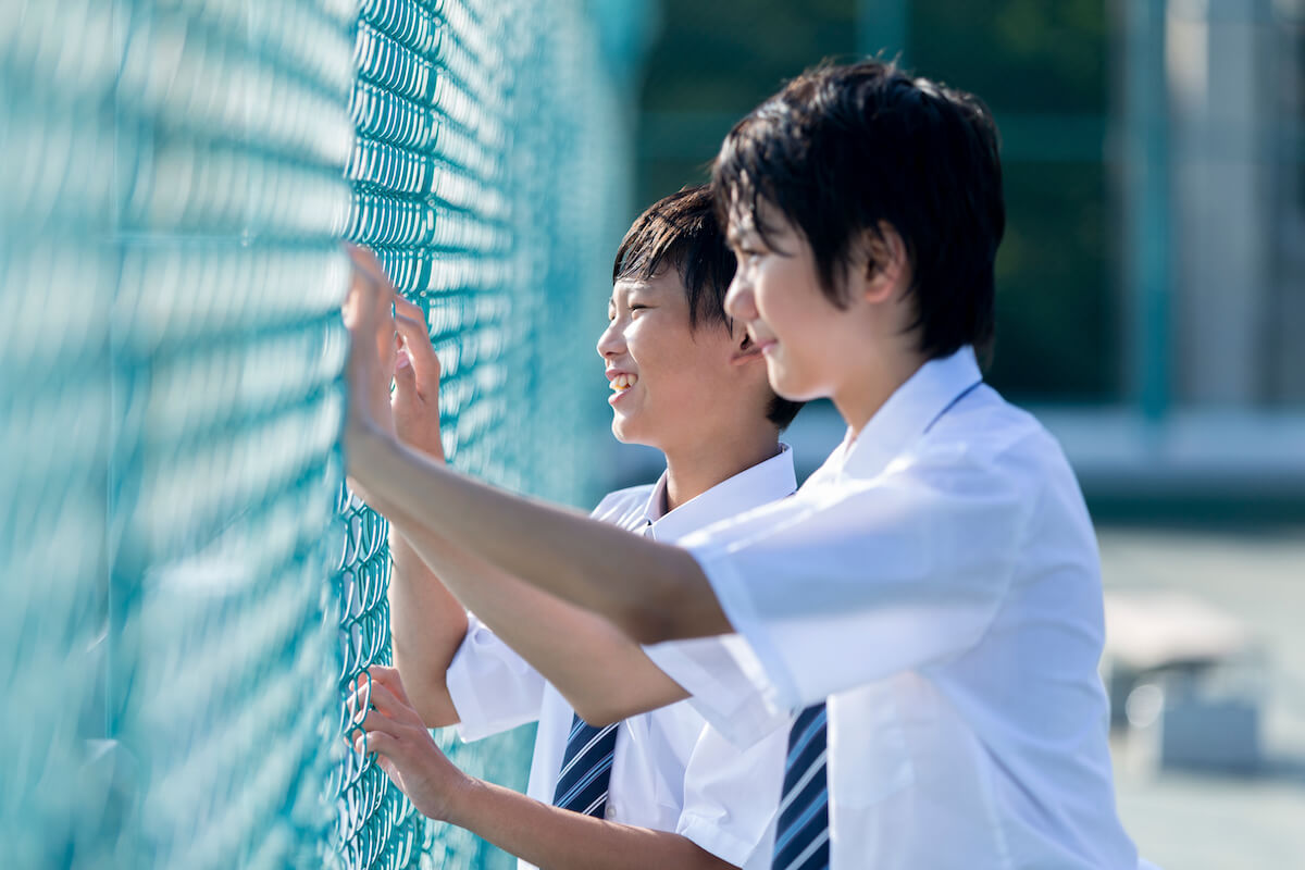 写真:学校の屋上で友人に声をかける少年