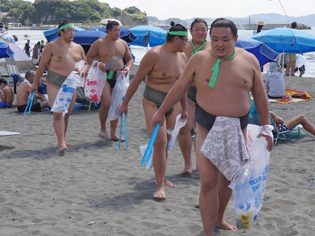 Photo of Sumo Wrestlers doing beach cleaning activities