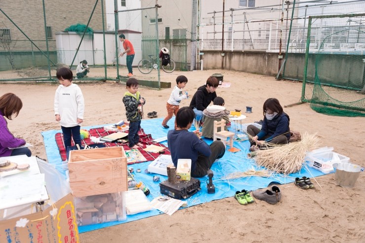 写真:藁を使って自由に遊ぶ子供たち