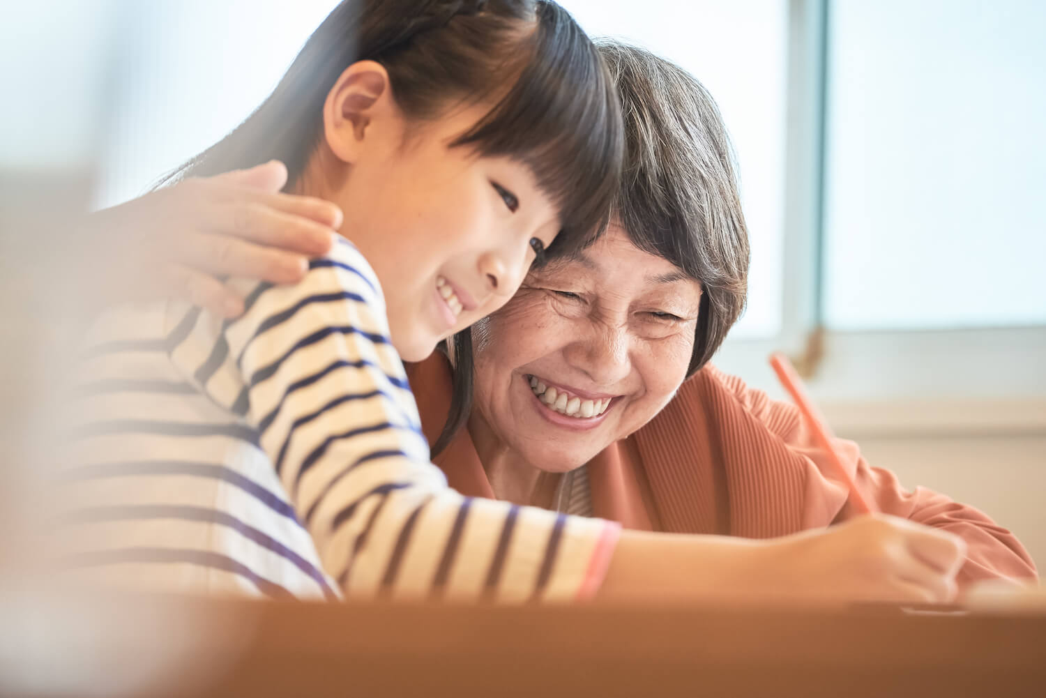 写真：少女に勉強を教えるおばあさん