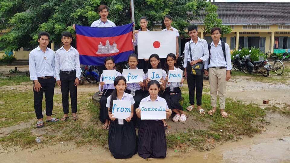 写真：「pray for Japan from cambodia」というメッセージカードを持ったカンボジアの生徒たち
