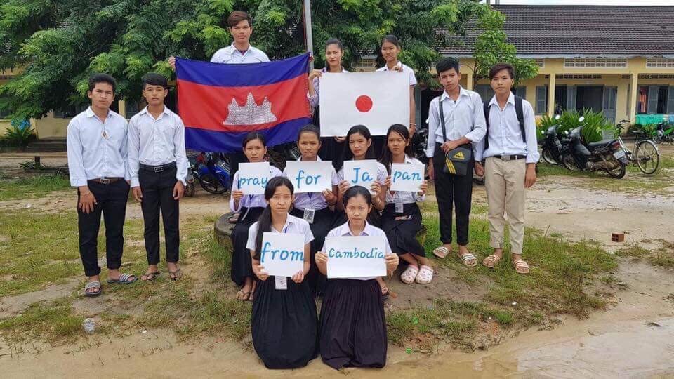 写真:「pray for Japan from cambodia」というメッセージカードを持ったカンボジアの生徒たち