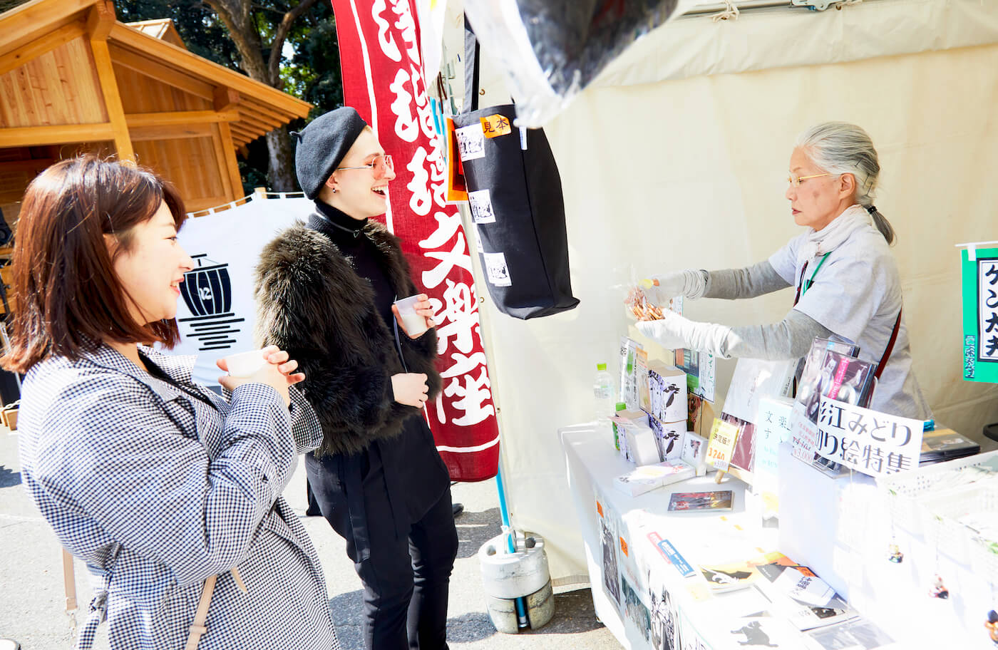 写真：売店スタッフと笑顔で話を交わす田村さん（左）とナナさん（真ん中）