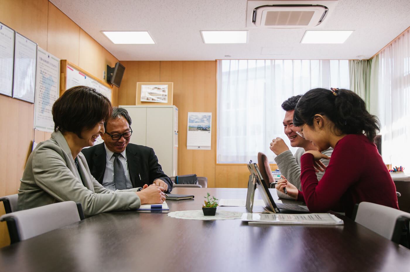 写真：学校の一室で先生たちと話をする浅谷さんとアローズのスタッフ