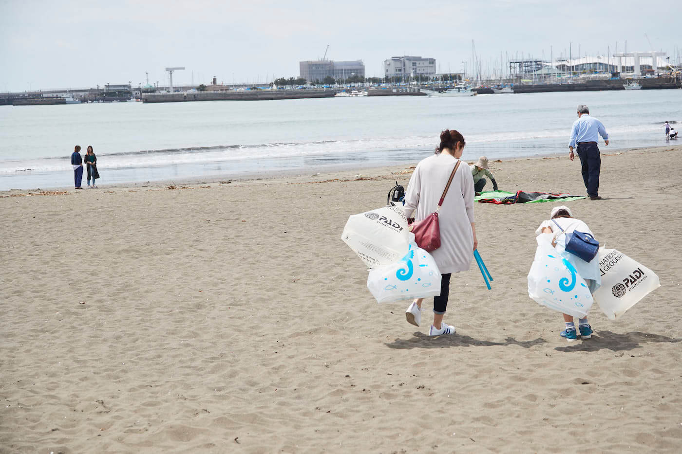 写真：砂浜でごみを拾う参加者の母と息子