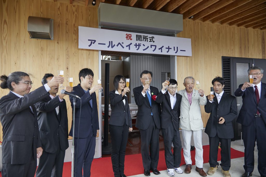 写真：ワイナリーの開所式で祝杯を挙げる施設のスタッフと宮澤さん（左から2番目）、笹川会長（右から3番目）、花巻市長の上田さん（右端）
