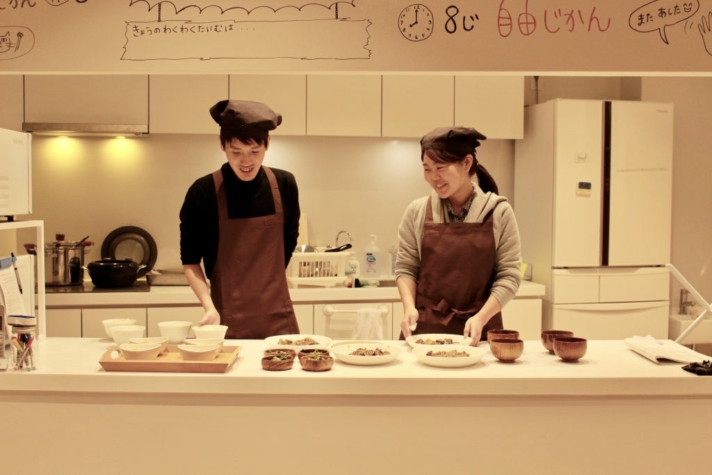 写真：キッチンで夕食の準備をする2人のスタッフ