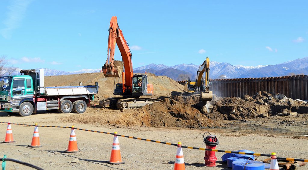 写真：堤防の本復旧に向けた工事で、ショベルが掘った土をトラックに積む様子 