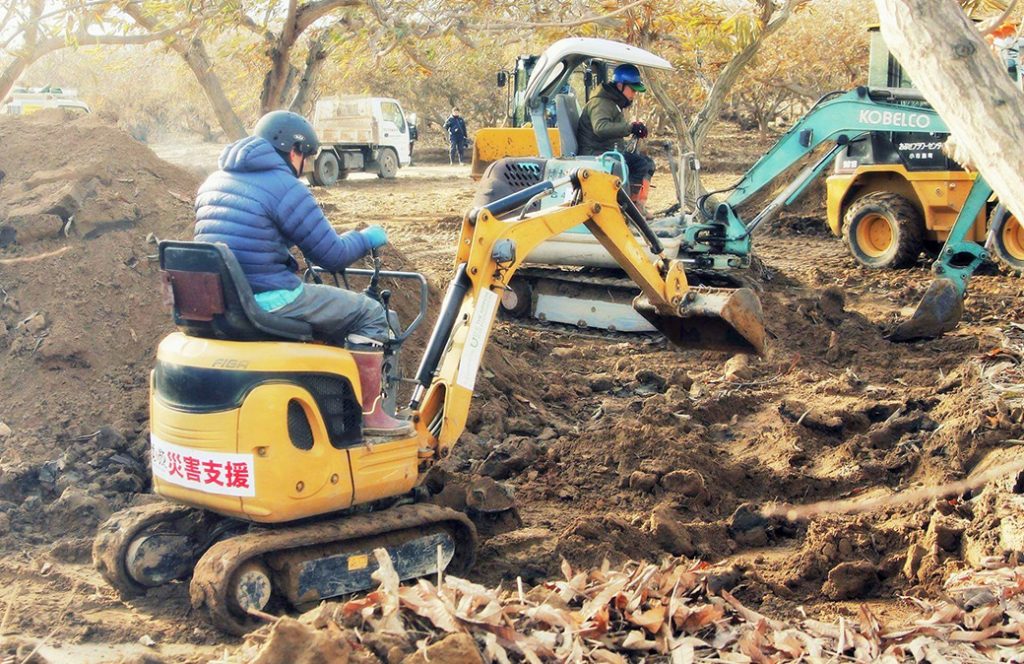 写真：栗畑にたまった泥をボランティアが重機を使ってかき出す様子（2019年12月、小布施町、日本笑顔プロジェクト提供）