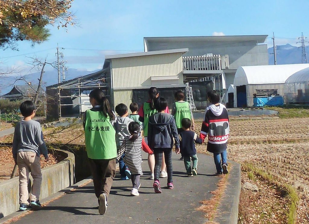 写真：晴れた秋の日、被災地の子どもたちを連れて、高校生が散歩に出かけました。手を引いて歩く生徒もいました（11月24日、横沢祥子さん提供）