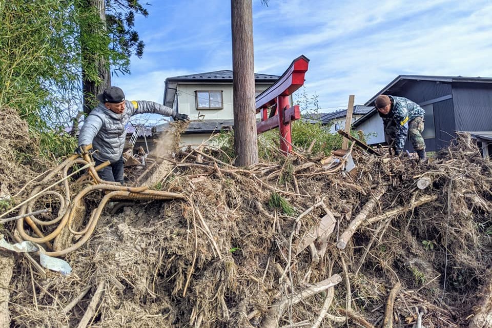 写真：スマイルシードのスタッフらが、鳥居周辺を埋め尽くしている流木を、チェーンソーを使いながら取り除きました（2019年12月、黄本さん提供）