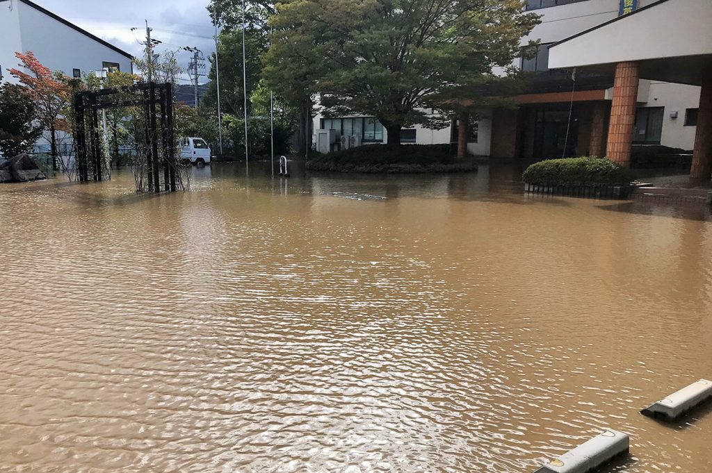 写真：玄関や駐車場が泥水に浸水した様子（10月13日、学校提供）