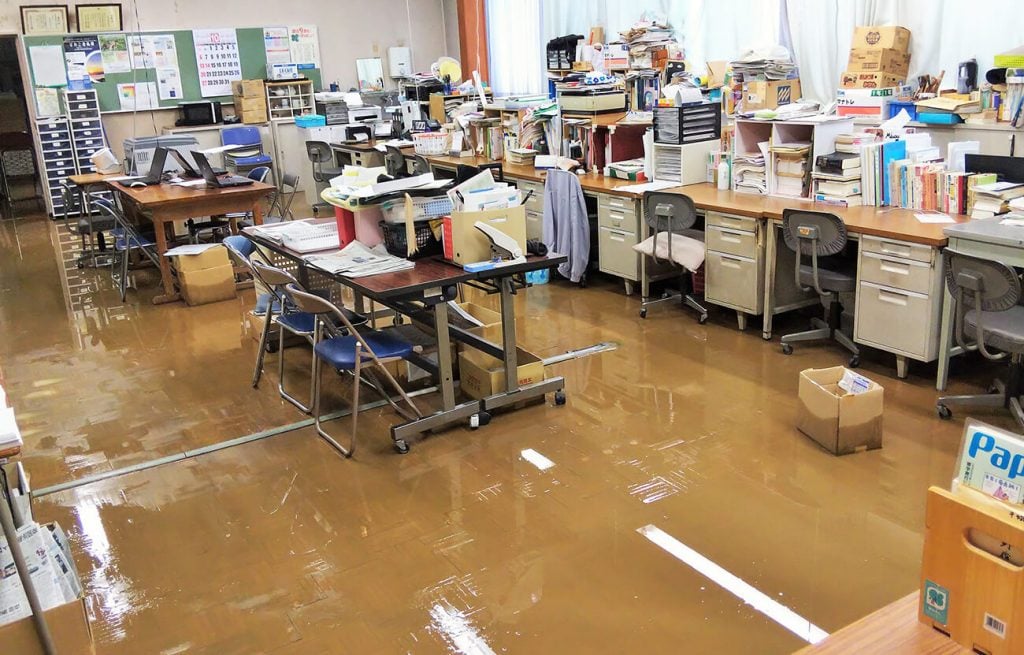 写真：校舎1階の職員室も浸水し、フロアに泥水がたまっています（10月13日、学校提供）