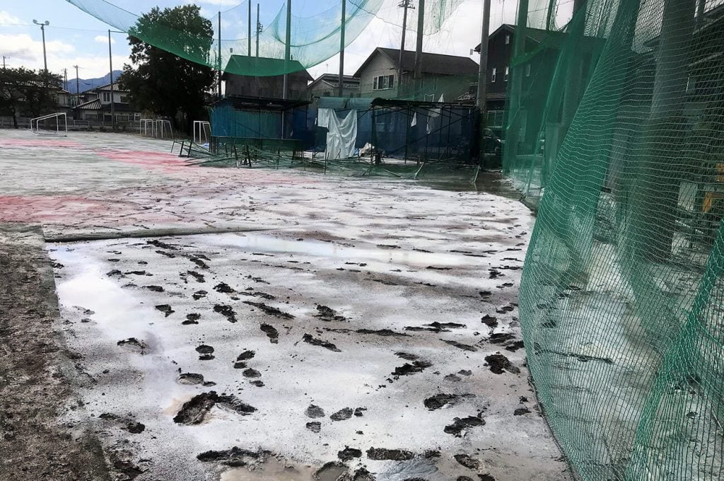 写真:消毒のために消石灰がまかれ、雪が積もったように白くなったグラウンドの様子(10月19日、学校提供)