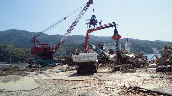 写真：東日本大震災で被災した港であった漁業支援の様子（2011年8月、石巻市、萬代さん提供）
