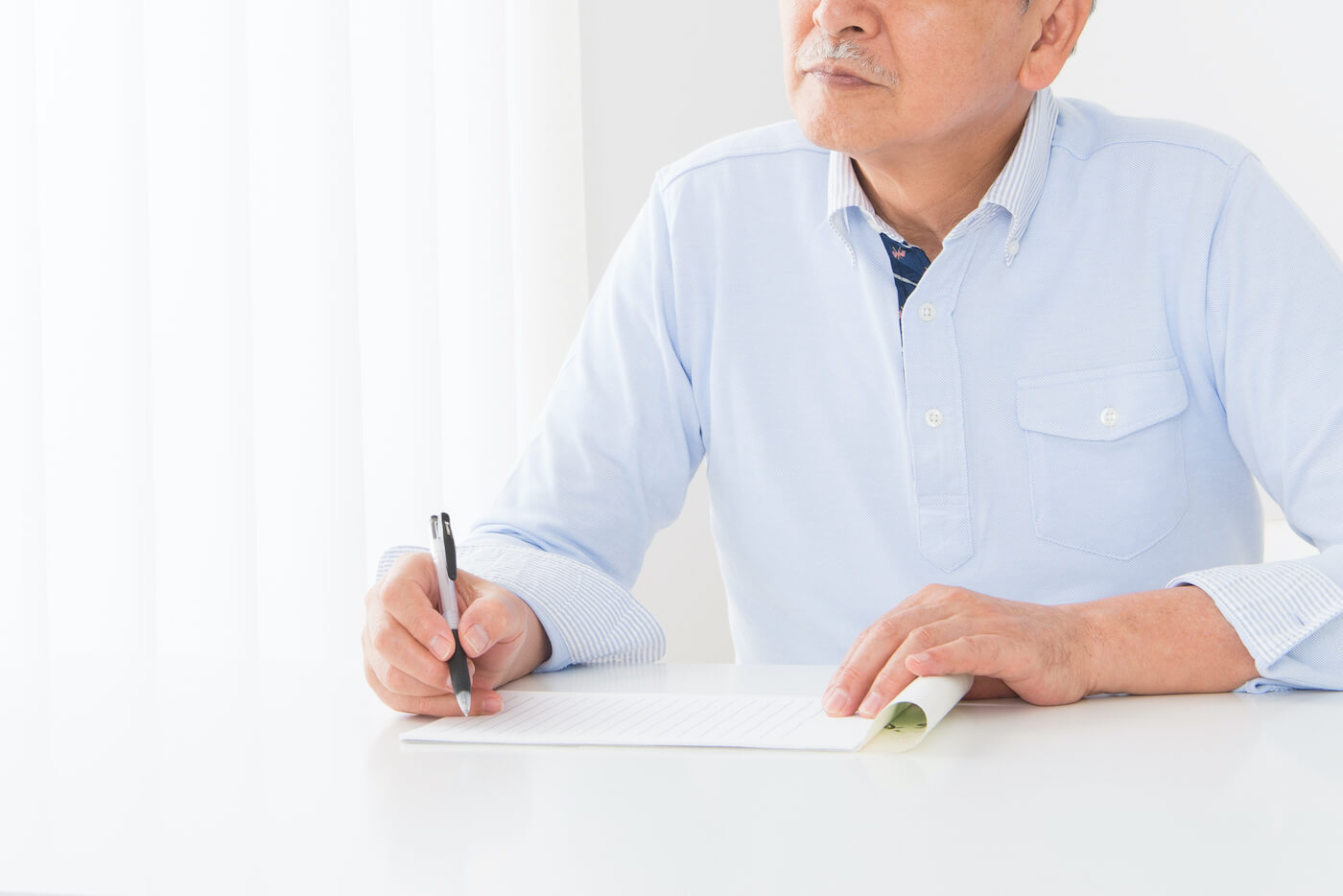 写真：遺言を書く男性の老人