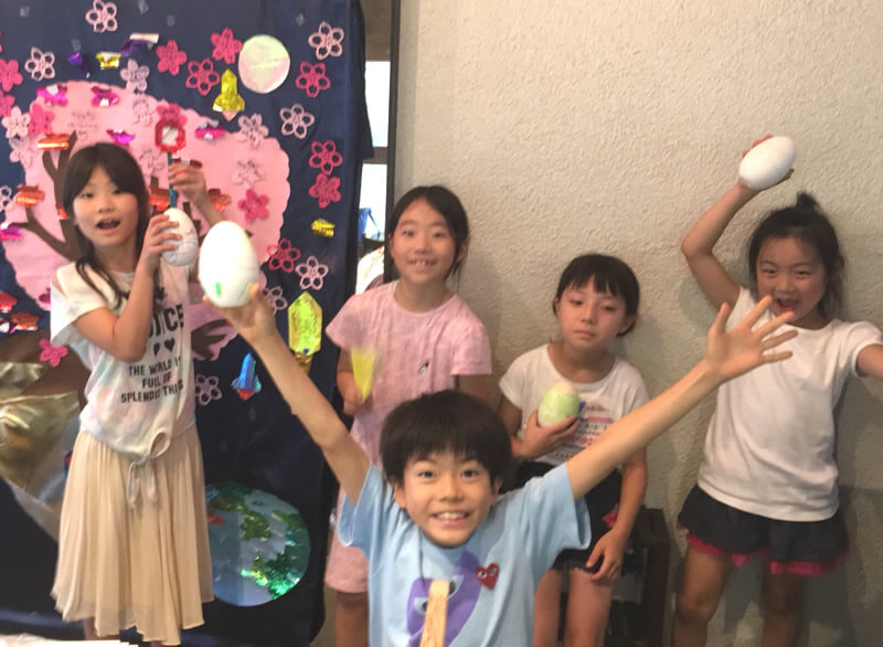 写真：桜丘こどもテーブル ～渋谷のラジオの教室～」で行われたアートワークショップで、自分で作った作品を持って記念撮影する子どもたち