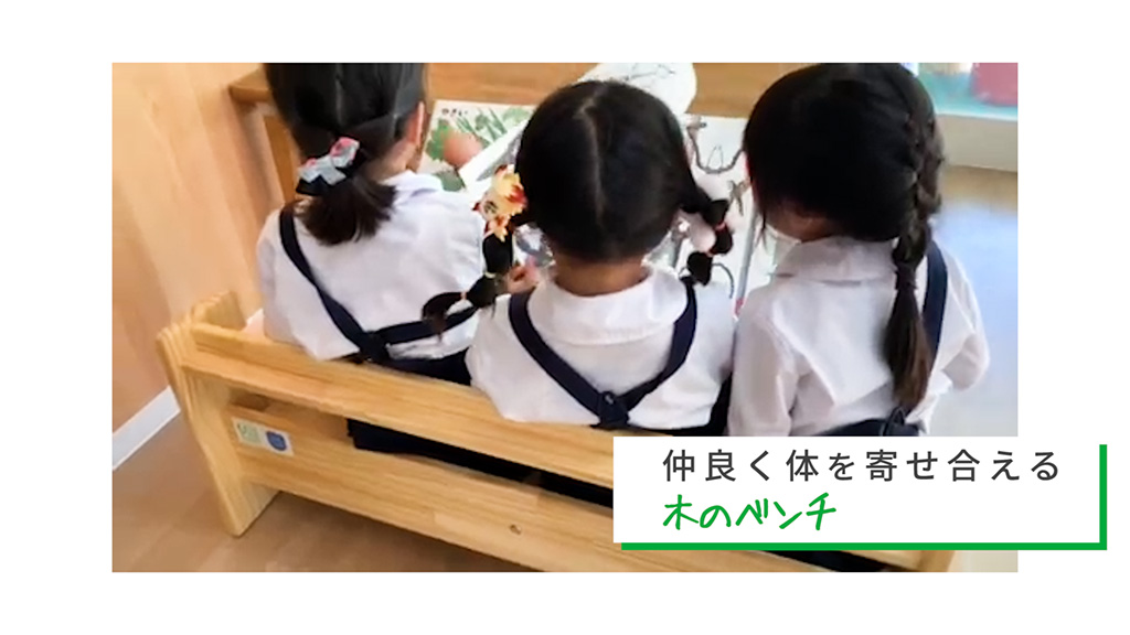 「日本財団 活動紹介動画 被災地の教育現場への支援」1シーン。画面右下に「仲良く体を寄せ合える木のベンチ」の文字。