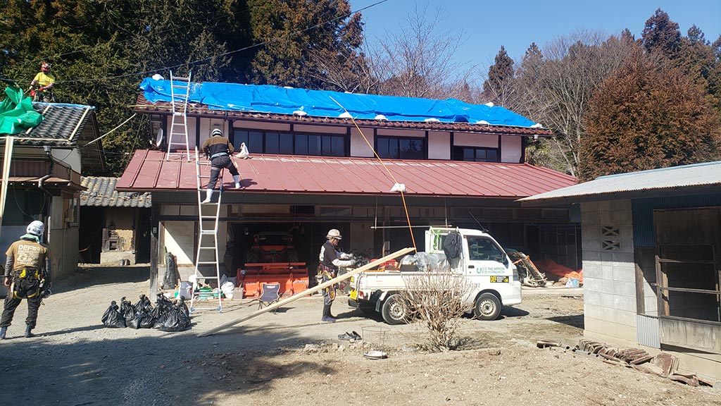 写真：被災地で壊れた屋根の補修作業をする様子