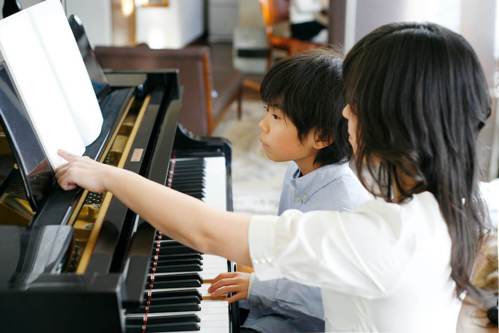 写真：ピアノ教室で講師にピアノを習う子ども