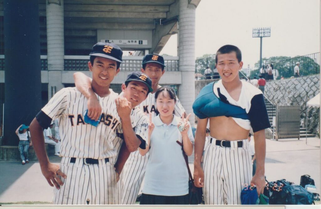 写真：チームメートとマネージャーと一緒に記念撮影する野球少年だった時の三浦さん