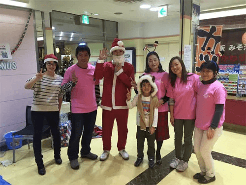 写真:キャンナス本部で開かれたクリスマス会の様子。キャンナスのメンバー、子どもと一緒に記念撮影