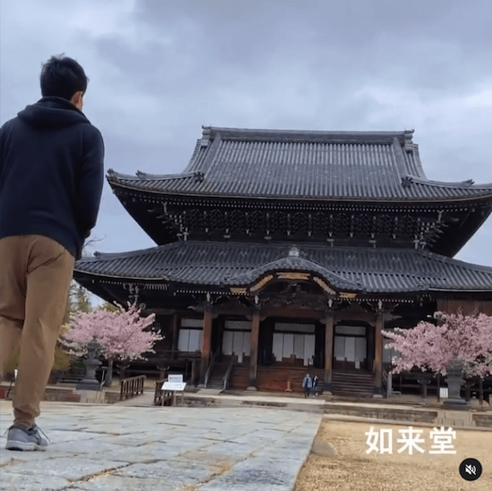 写真：高田本山専修寺の如来堂の前に立つ動画を制作した高校生