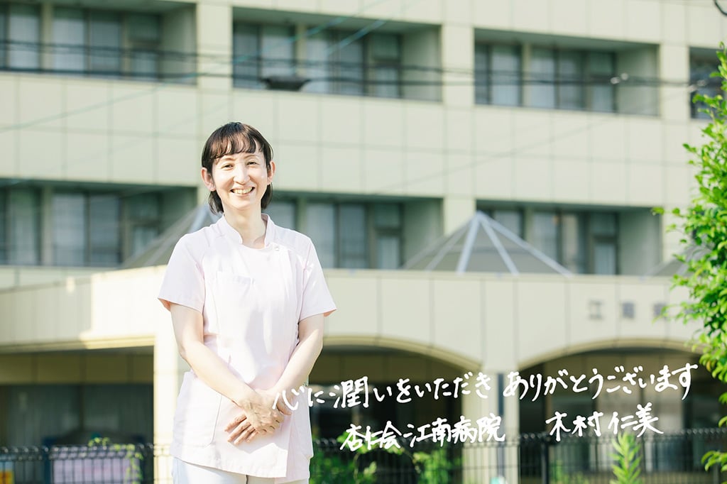写真:杏仁会江南病院 看護部長 木村仁美さん。画像下側にメッセージ「心に潤いをいただきありがとうございます」の文字