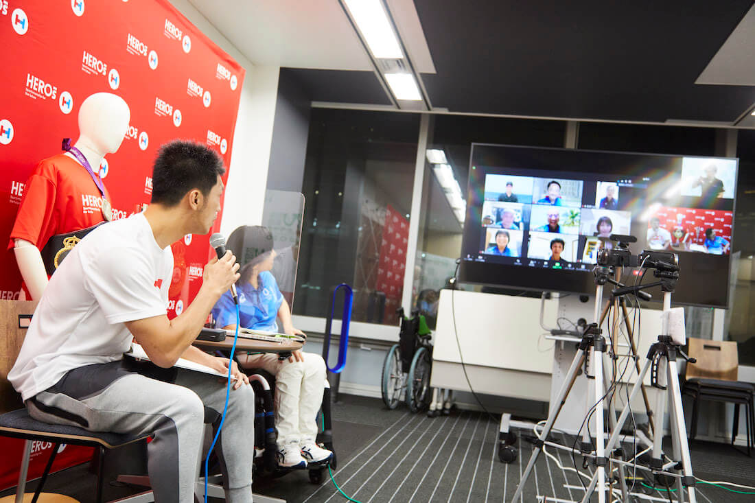 写真：テレビ画面を通して、オンラインで参加したボランティアと交流する村田さんと田口さん