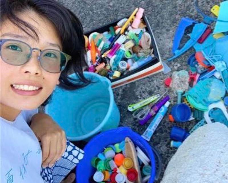 写真:海岸で拾ったごみと一緒に写るあやおさん