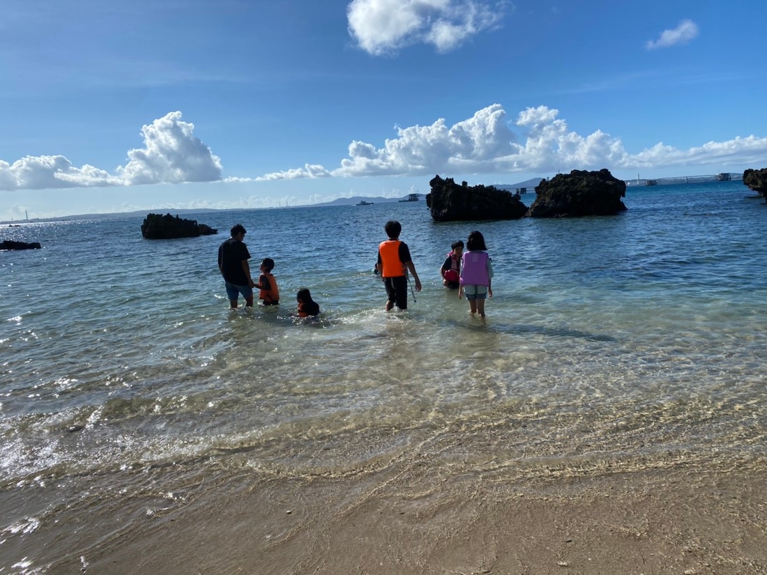 写真：沖縄の美しい海で遊ぶ B拠点に通う子どもたち