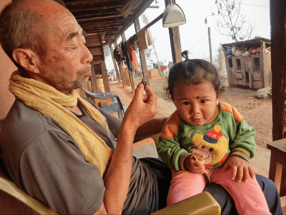 写真：パルパ郡の子どもを膝に乗せて世話をする垣見さん