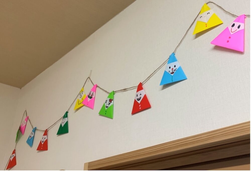 写真: C拠点の壁に飾れた折り紙で作った色とりどりのサンタ