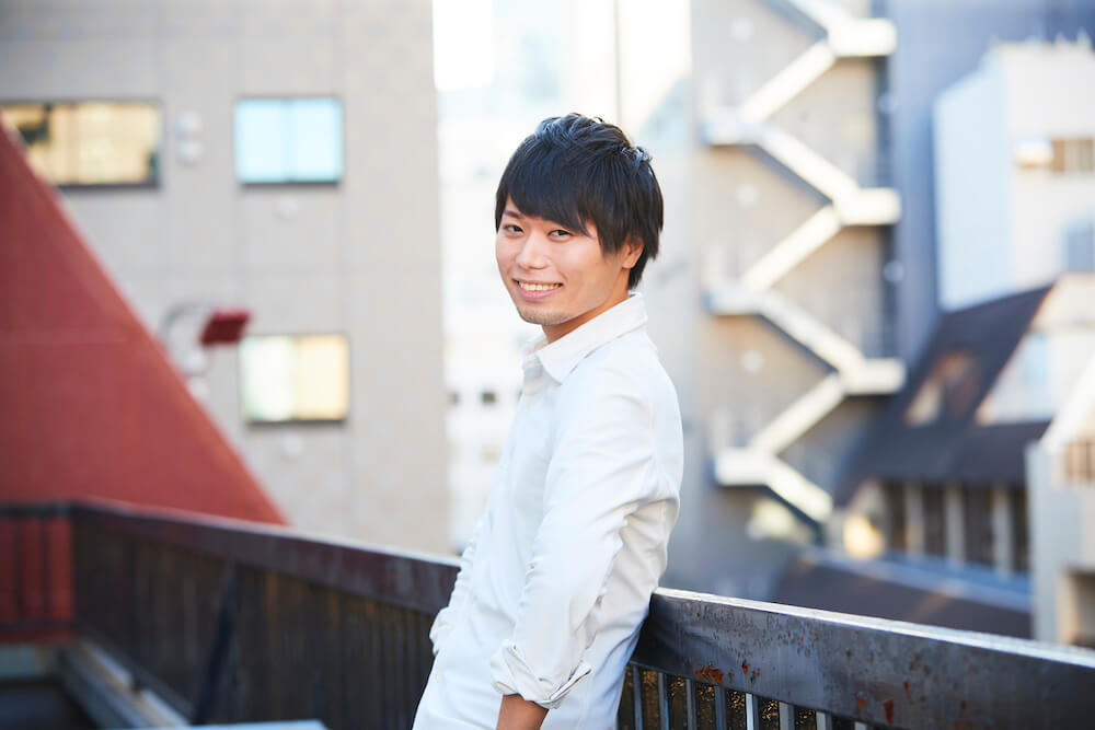 写真：柵にもたれながら笑顔を向ける永井さん