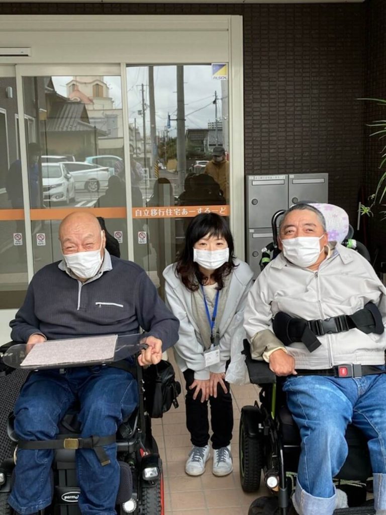 写真:車いすを利用する2人の重度障害者と一緒に記念撮影をするホームケア土屋のスタッフ