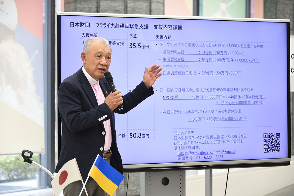 Photo of Yohei Sasakawa explaining the support program