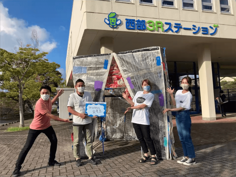写真:『iroiro交差点』の前で記念写真を撮影するしばたさんと仲間たち