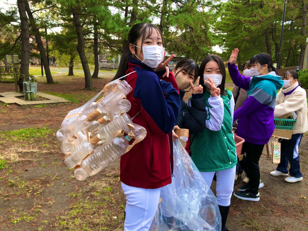 写真：オリジナルアイテムでごみ拾いをする女子高生たち