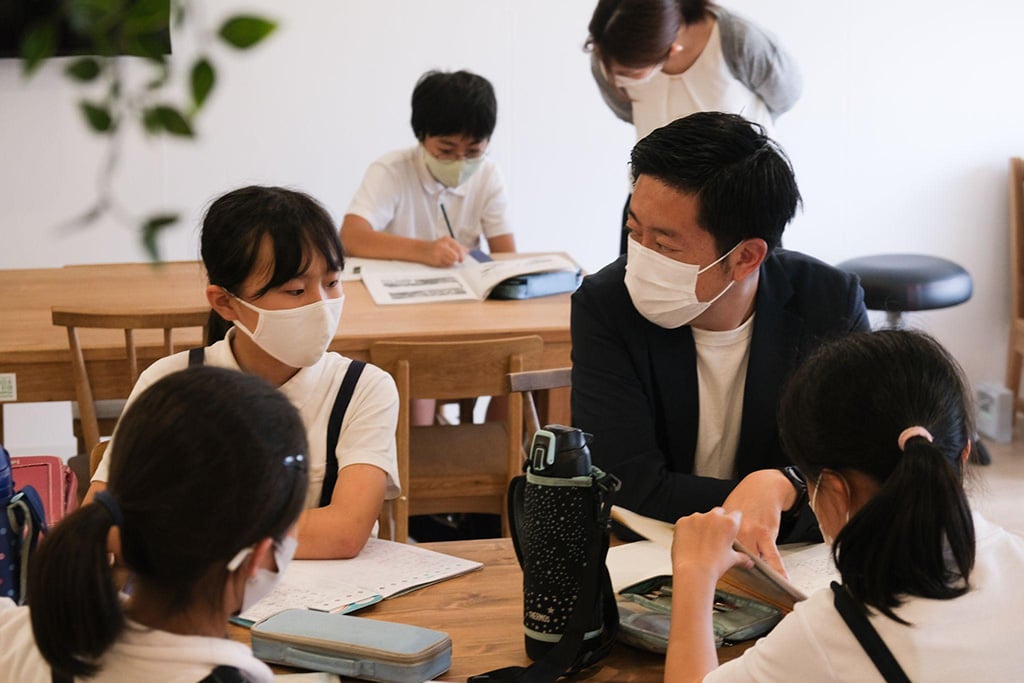 写真:キリンの家で水取さんと勉強をする子どもたちの様子
