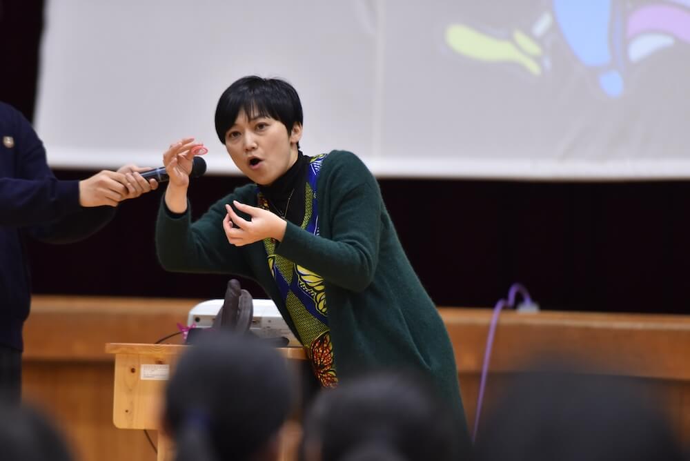 写真：体育館で高校生の前に立ち性教育について出前授業を行う清水さん