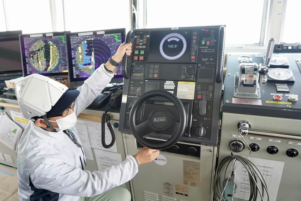 Photo of the pilothouse of the container ship SUZAKU – a switch under the handle transfers control to the land-based Fleet Operation Center