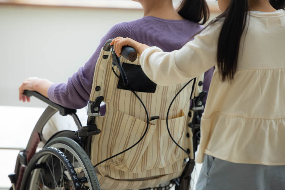 写真：母親の車いすを押す子ども