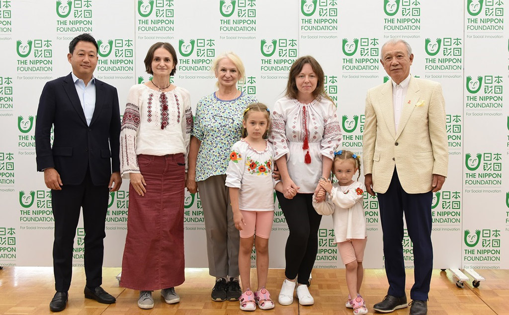 Photo of press conference participants (left to right): The Nippon Foundation Executive Director Jumpei Sasakawa, guarantor Olena Svidran and her mother, Nataliia Muliavka and her two daughters, and The Nippon Foundation Chairman Yohei Sasakawa