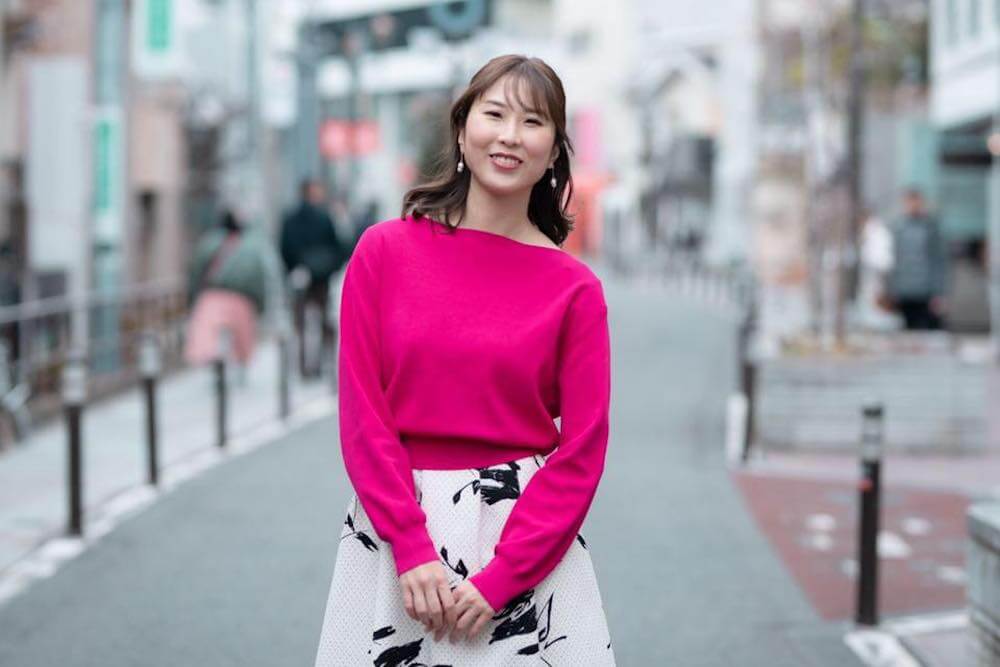 写真:路上に立ち笑顔を向ける田中さん