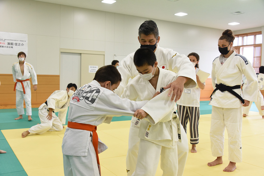 Photo of Kosei Inoue instructing two young judoka