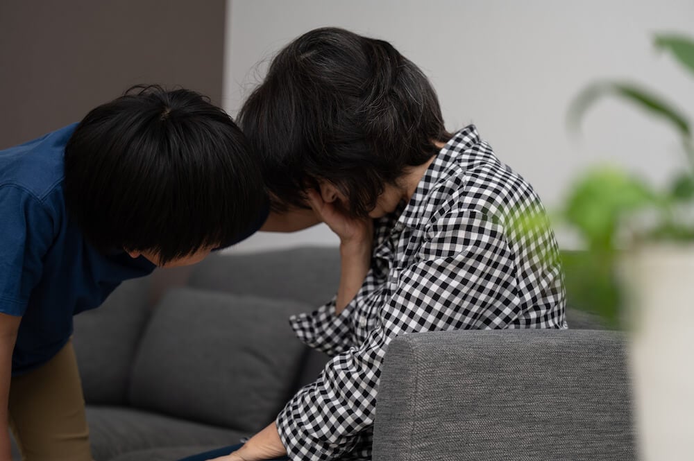 写真:鬱や病気で元気がない祖母を励ます子ども