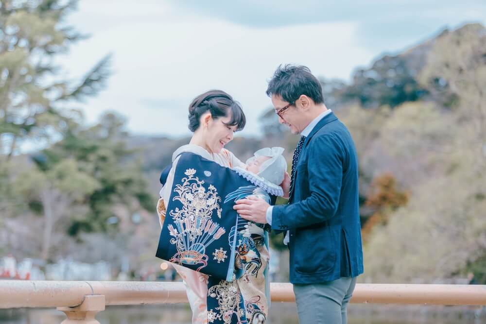写真：赤ちゃんを抱く母親の池田麻里奈さんと赤ちゃんを包み込むように支える父親の池田紀行さん