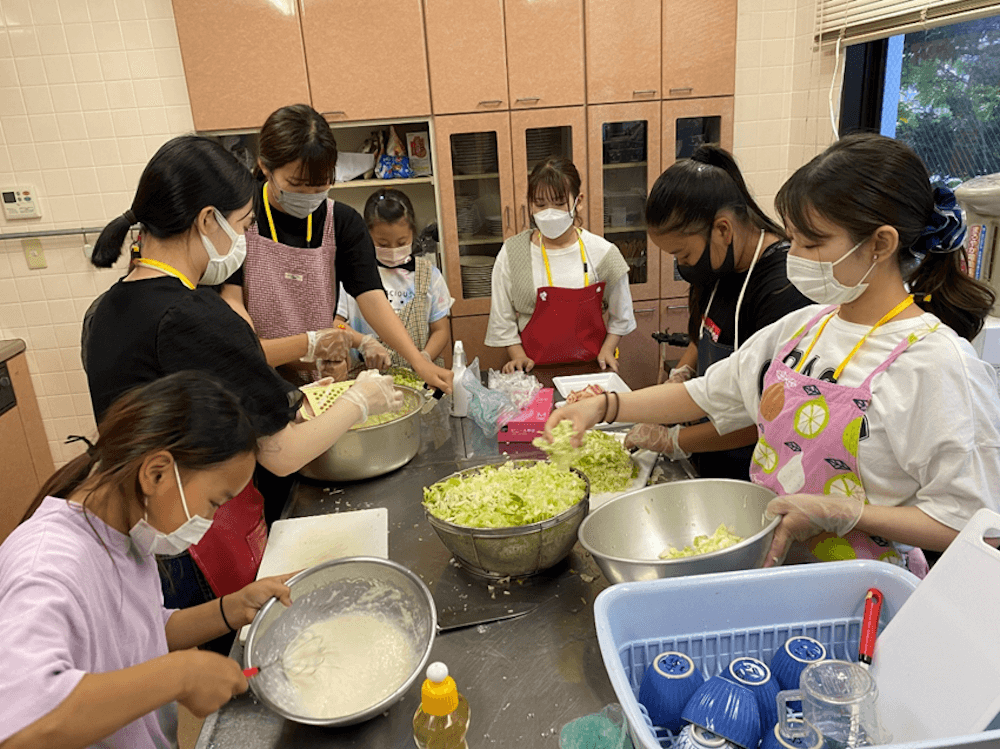 写真：お好み焼きの準備をする子どもたちとスタッフ